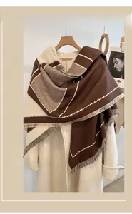 Detailed view of thick color-block shawl with fine fringe edges and geometric borders