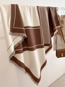 Detailed view of color-block scarf texture with elegant tassels in brown and beige