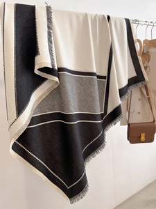 Detail of color-block winter shawl showing soft cashmere-like texture and tassel fringe edges