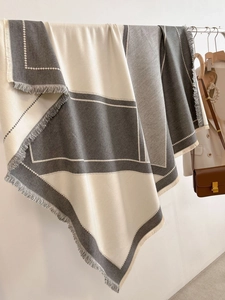 Close-up of geometric grey and beige tassel shawl showing fine diagonal twill texture