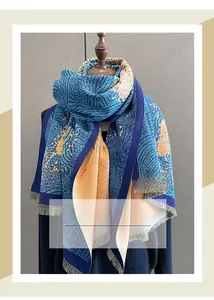 Detail of dark blue cashmere-like scarf with orange artistic pattern and short fringes