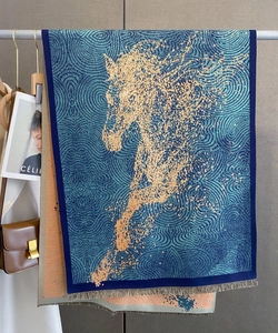 Detail of navy blue cashmere-feel shawl featuring gold horse motifs and fine fringe edges
