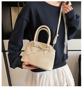 Detail showing the cream ribbed texture tote bag with silver buckle and detachable strap