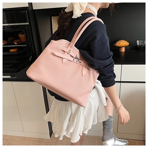 Close-up of pink pleated tote bag with metal buckle detail and soft texture