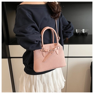 Detailed view of pink shell tote bag with vertical pleated texture and silver buckle strap