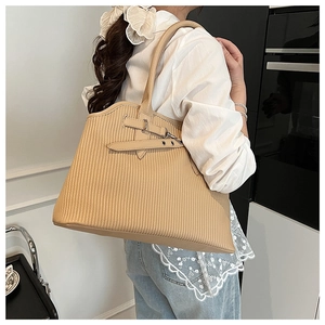 Detail of pleated textured tote bag in beige leather with adjustable buckle strap