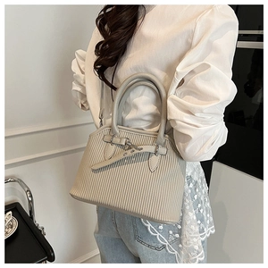 Detail of light gray tote bag with vertical pleated texture and metal buckle fasteners