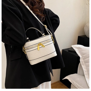 Detail of white litchi pattern leather vanity case with black trim and gold zippers