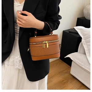 Detail of vintage brown textured leather box bag with dual metal zippers and top handle