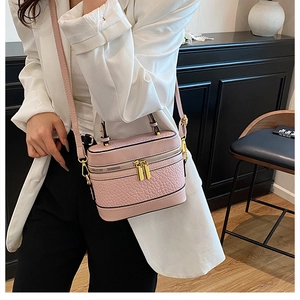 Detail of pink croc-embossed box bag with gold hardware and structured top handle design