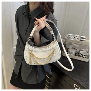 Detail of white crocodile pattern shoulder bag with gold chain and adjustable strap