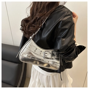 Dettaglio borsa a spalla argento metallizzato con fibbie metalliche su giacca in pelle nera
