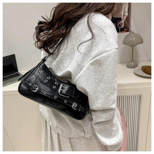 Dettaglio di una borsa baguette nera in stile vintage con fibbie in metallo e occhielli
