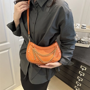 Chic orange crocodile pattern crescent bag with dual gold chain accents and strap