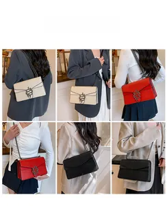 Detail of crossbody bag with crocodile pattern leather and snake-shaped metal buckle