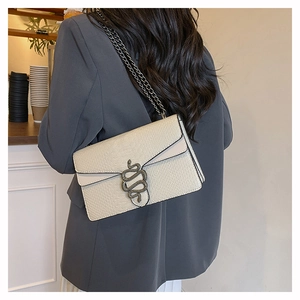 Detail of snake pattern shoulder bag featuring vintage metallic snake-shaped clasp and chain