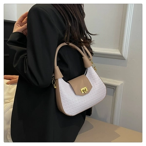 Close-up of crescent woven bag featuring white texture and premium brown leather straps