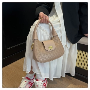 Detail of woven texture khaki hobo bag featuring a gold twist lock for high-end fashion
