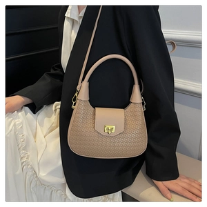 Detail of woven crescent crossbody bag with gold metal buckle and leather handle