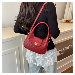 Detail of red woven texture Hobo bag featuring a gold metal twist lock and dual strap design