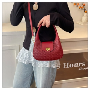 Detail of burgundy woven hobo bag with gold twist lock and adjustable shoulder strap