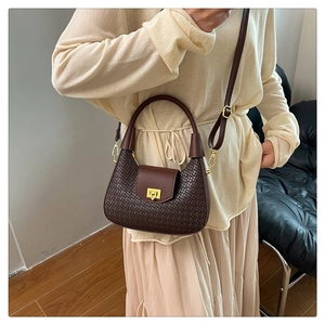 Detail of dark brown hobo bag featuring woven texture and gold square rotary lock