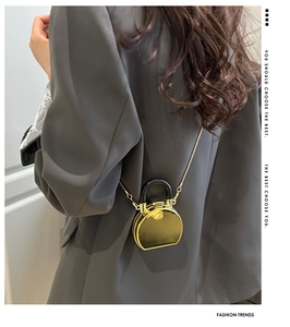 Detailansicht der Mini-Gold-Spiegeltasche mit Metallkette und rundem Griff
