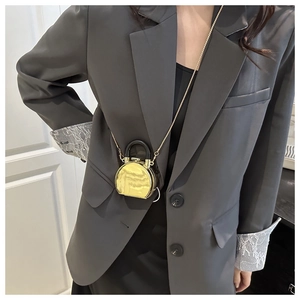 Detailansicht einer Mini-Tasche mit goldenem Spiegeleffekt und Metallkettenriemen