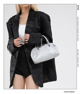 Close-up of silver snake-pattern texture on handbag with stylish metal chain detail