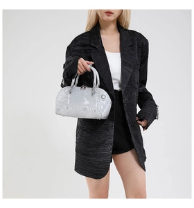 Detail of silver snake skin texture and metallic finish on a barrel handbag with handles