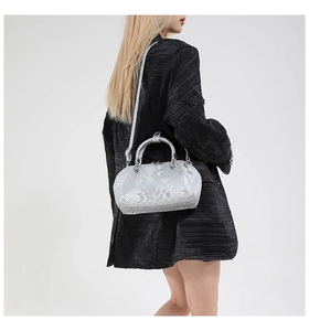 Detail view of silver snakeskin embossed shell bag with metallic studs and handle