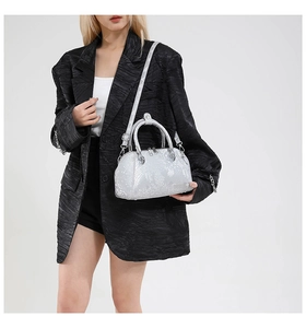 Detail of silver snake-embossed shell bag with leather texture and silver hardware