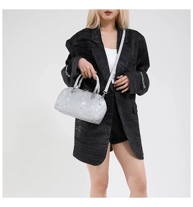 Silver snakeskin textured shell bag shown with a black blazer on a model