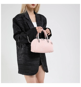 Detail of pink snake pattern shell bag with silver hardware on a black blazer model