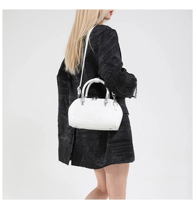 Detailed back view of a white snake pattern shell bag with silver hardware on a model