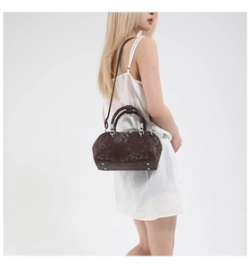 Model showcasing dark brown snake pattern handbag with elegant silver metal hardware