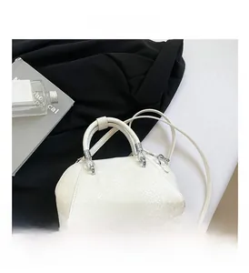 Macro shot of white snakeskin texture leather bag with silver metal ring handle detail