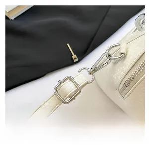 Detail of white snake embossed handbag featuring silver hardware and adjustable strap