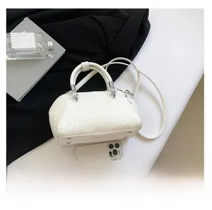 Detailed view of white snake skin texture on shell bag with silver hardware and strap