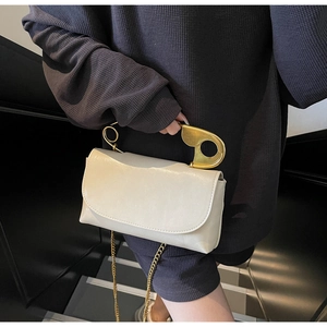 Close-up of the creative gold paperclip handle on the cream white square chain bag