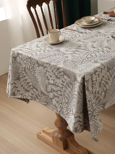 Detailed macro view of gray linen tablecloth with elegant white floral leaf patterns