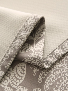 Close-up of thick linen tablecloth showing elegant leaf pattern and premium fabric texture