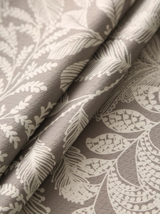 Detailed macro view of taupe linen tablecloth featuring embossed leaf patterns and texture