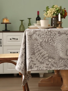 Detailed view of grey linen tablecloth with white fern pattern and premium hemmed edges