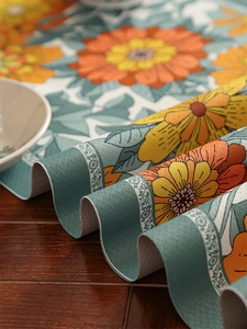 Close-up of vintage floral table runner with sunflower print and wavy edge texture