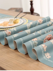 Detail of teal Chinese table runner with floral print on wooden table with dining set