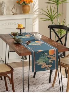 Detail of dark blue table runner with traditional landscape prints on a wooden table