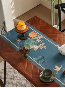 Detailed close-up of dark blue table runner with printed crane and mountain patterns