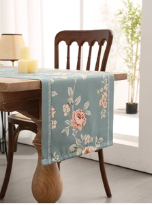 Detailed texture of thick waterproof table runner with floral rose pattern in light teal