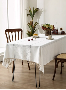 Detailed view of white French lace tablecloth featuring tassel edges and stripe textures